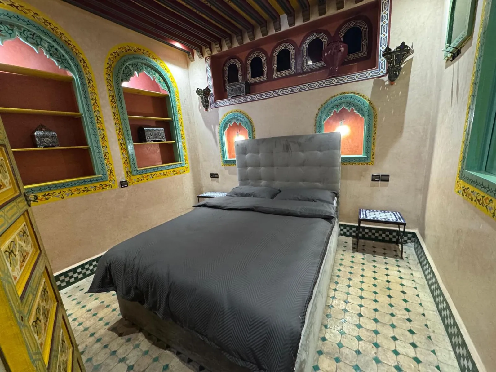 Une chambre, lit gris et niches peintes