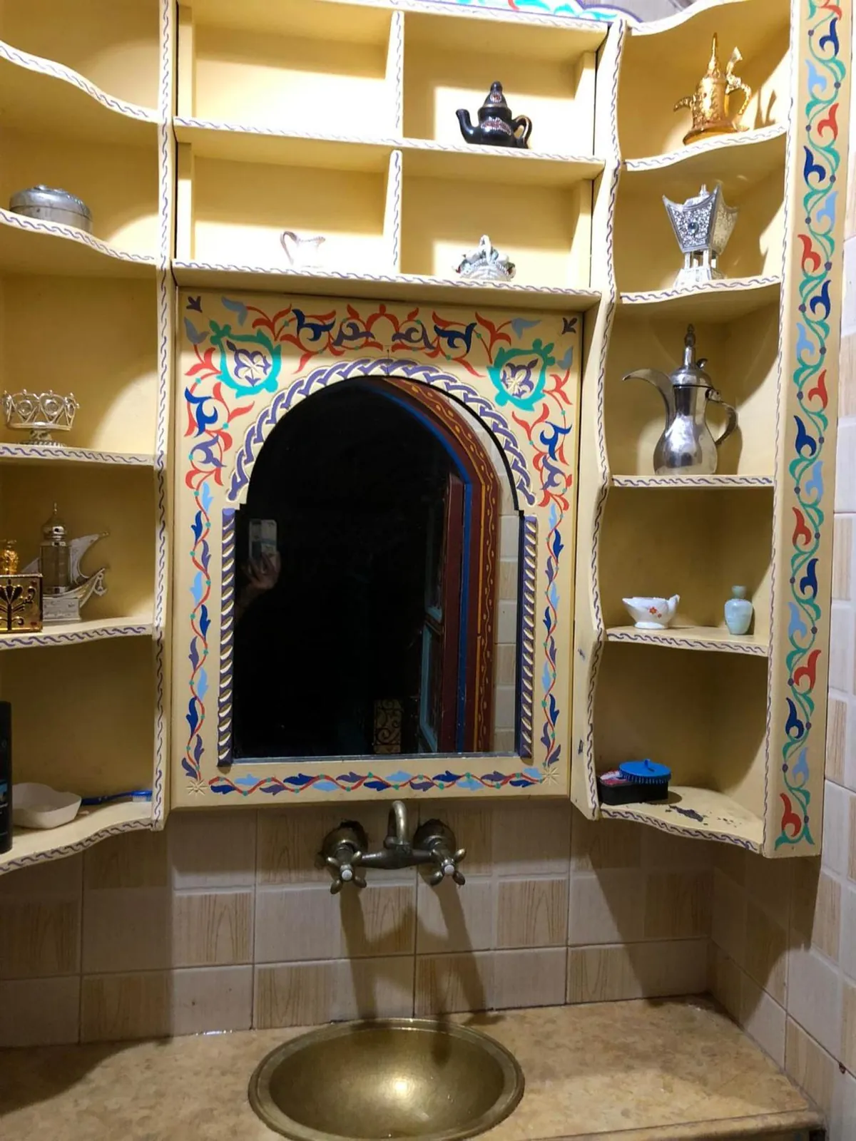 Un lavabo en cuivre dans une alcôve peinte