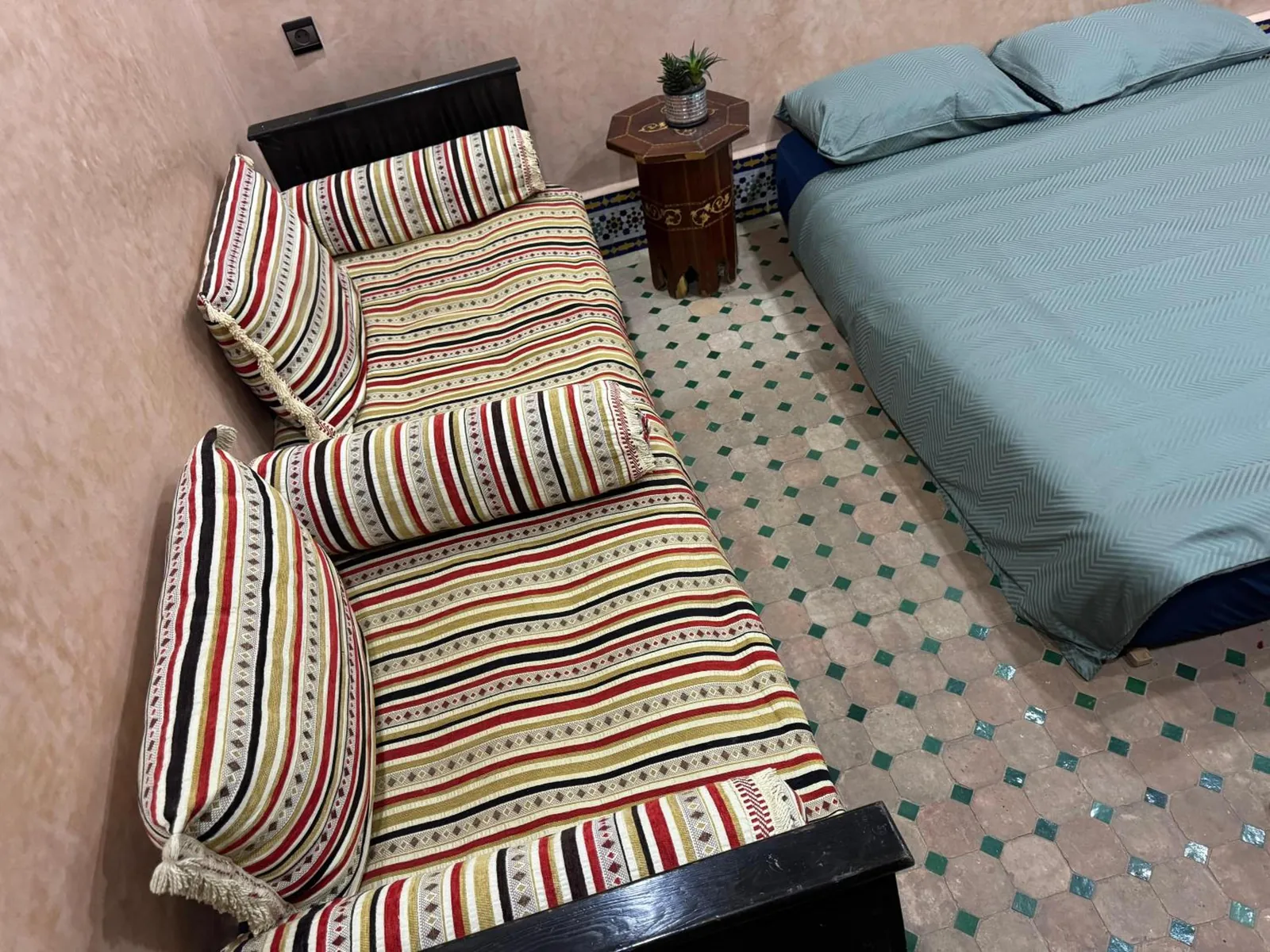 Une chambre, banquette rayée et grand lit