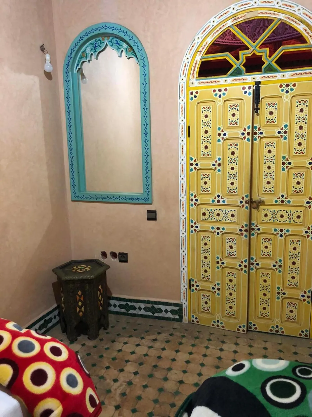 Une porte jaune peinte et un miroir turquoise