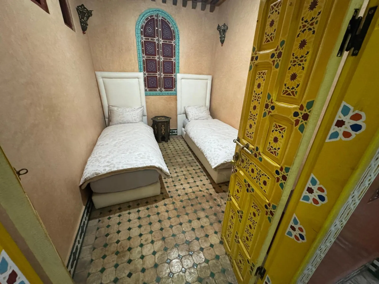 La chambre à lits jumeaux et sa fenêtre peinte