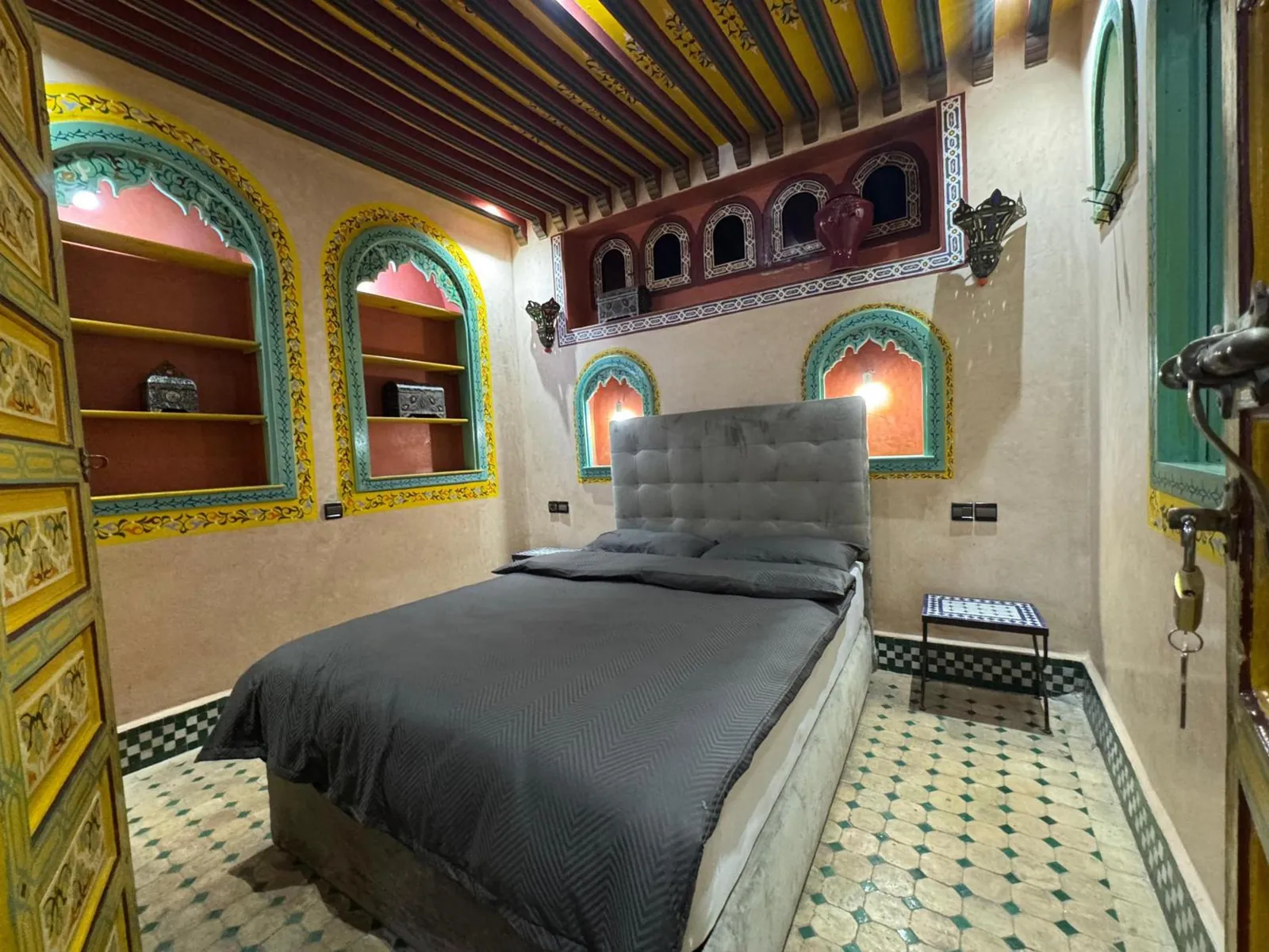 Une chambre, lit gris et niches turquoise
