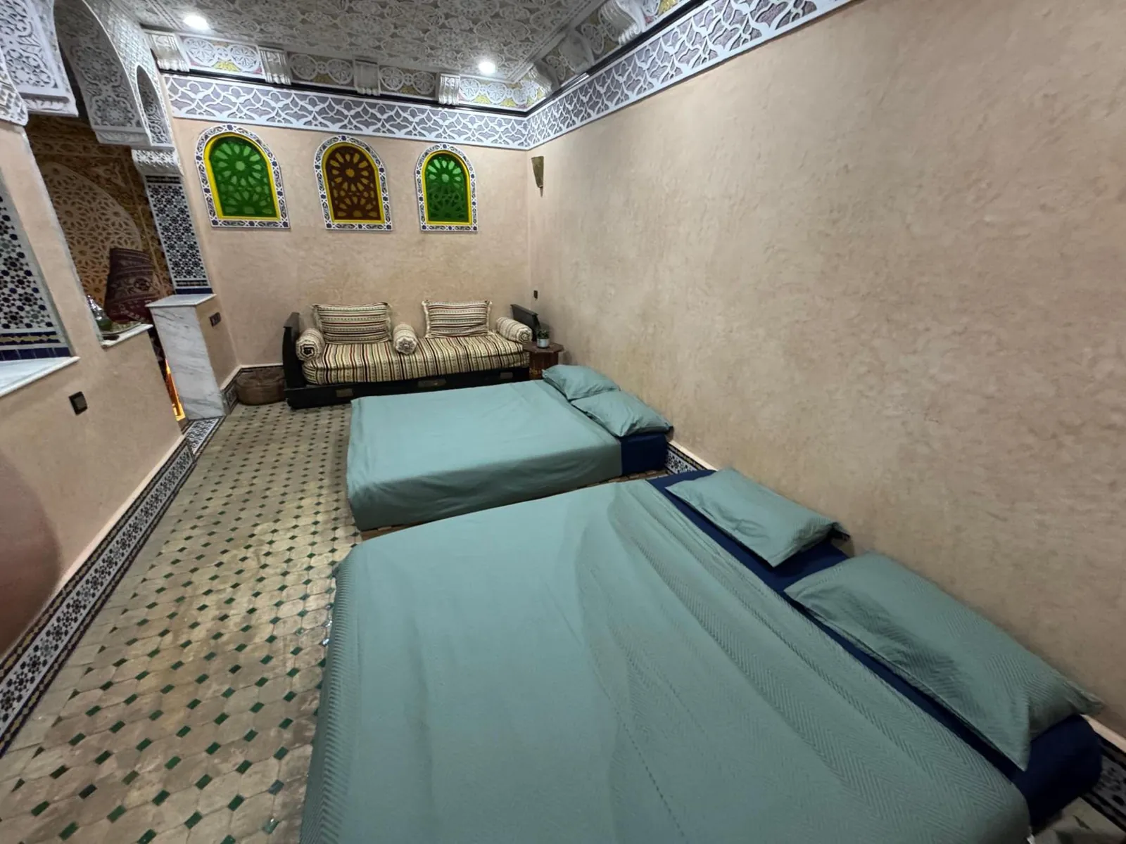 Une chambre, deux grands lits et une banquette