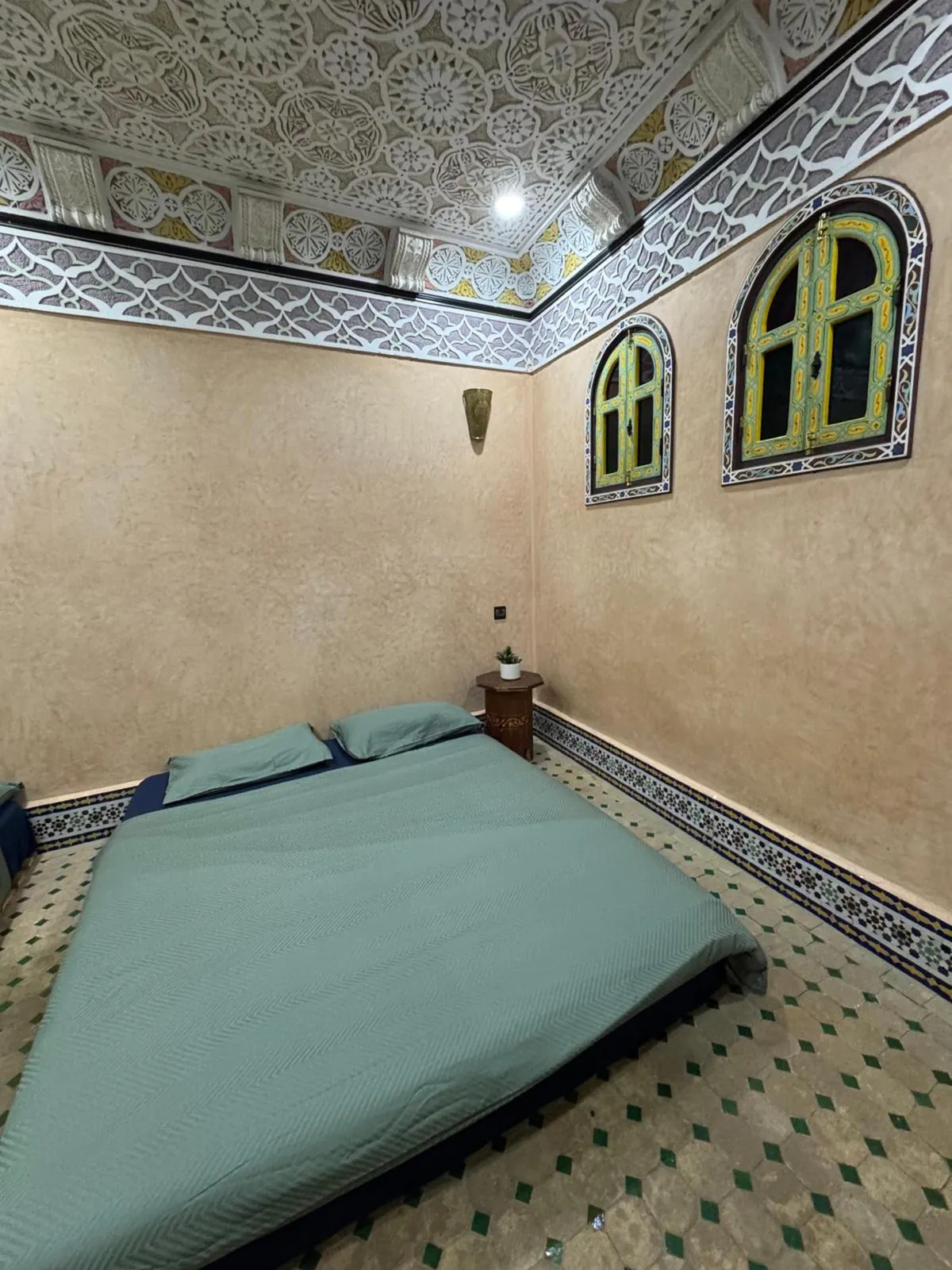 Une chambre, grand lit sous le plâtre sculpté